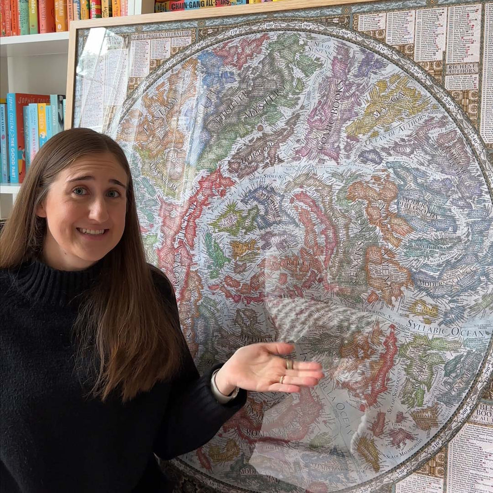 A reader pointing out literary regions on the framed map