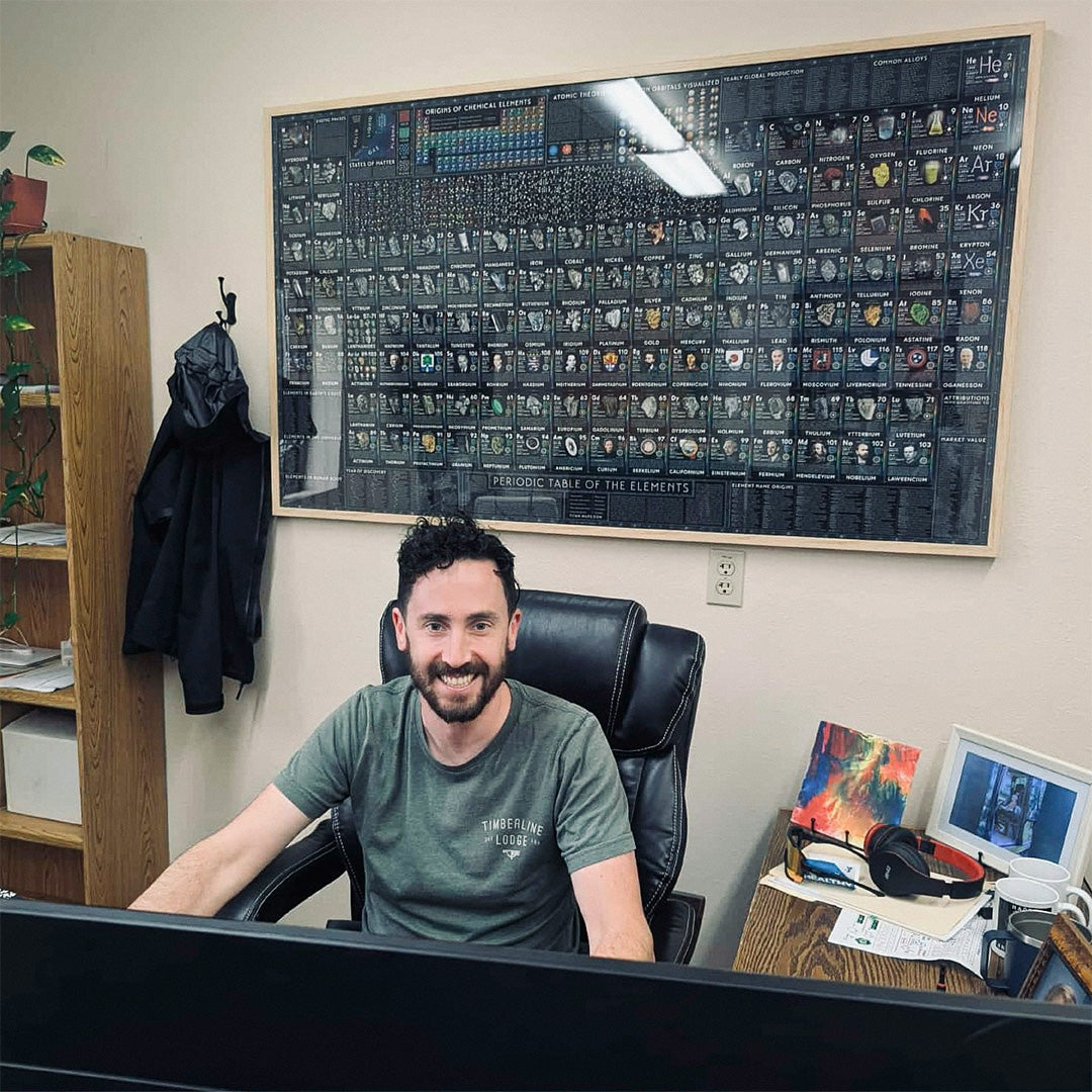 Framed World of Elements periodic table above a desk in Dr. M Jackson’s husband’s office